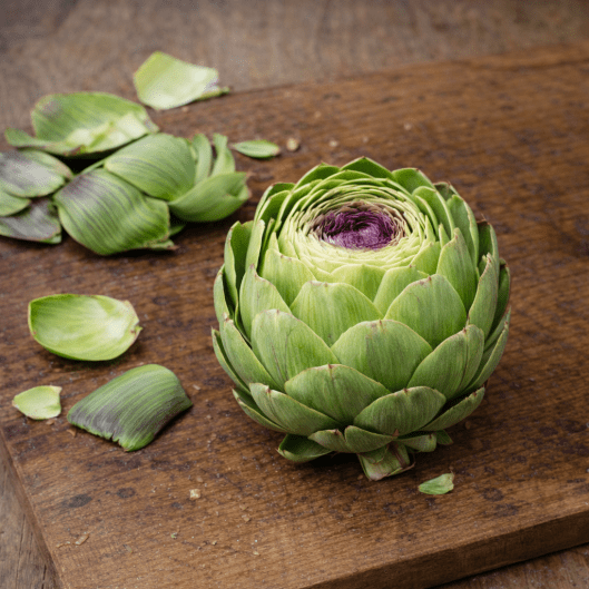 Removing outer leaves from a fresh artichoke before cooking